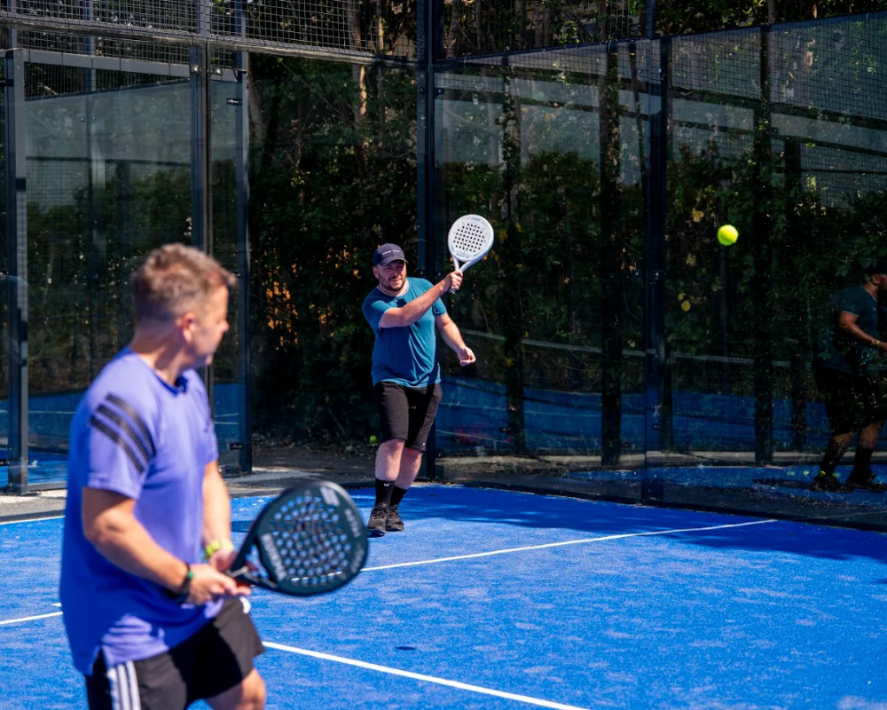 Players rallying on the padel court at Padel Tree Harlow